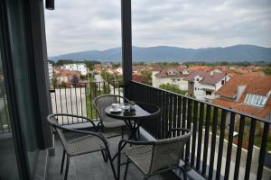 a balcony with two chairs and a table with a view at Apartman Dimić, Vrnjačka Banja in Vrnjačka Banja
