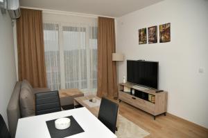 a living room with a television and a table at Apartman Dimić, Vrnjačka Banja in Vrnjačka Banja