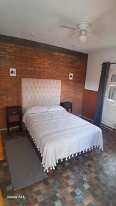 a bed in a room with a brick wall at Casa Bella Vizcaína in Mineral de Pozos