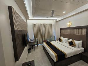a hotel room with a bed and a television at Hotel Abhinav International in Varanasi