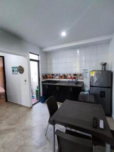 a large kitchen with a table and a refrigerator at Cabaña en condominio frente al mar #10 in Tolú