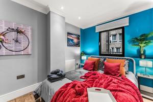a bedroom with blue walls and a bed with a red blanket at Beautiful 2 Bedroom Home In Bristol in Bristol