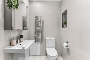 a white bathroom with a toilet and a sink at Beautiful 2 Bedroom Home In Bristol in Bristol
