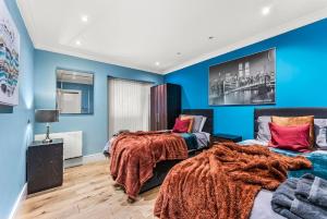 two beds in a room with blue walls at Beautiful 2 Bedroom Home In Bristol in Bristol