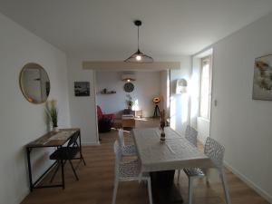 a dining room and living room with a table and chairs at Appart 2 Chambres, Proche Gare, Wifi, Jardin, Parking in Montélimar