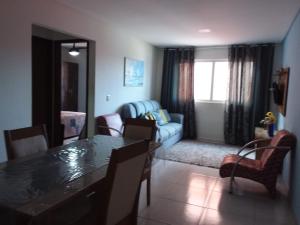 a living room with a table and a blue couch at Condomínio Bezerra in Maragogi