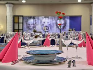 una mesa con servilletas rojas y copas de vino. en Mercure Gdańsk Stare Miasto, en Gdansk