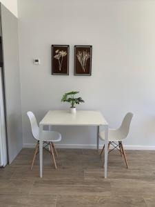 una mesa blanca con dos sillas y una planta en ella en M Tower, en Neuquén