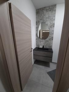 baño con puerta de madera y espejo en Apartman Luna, en Makarska