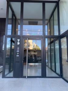Una puerta de cristal de un edificio con el número tres. en M Tower, en Neuquén