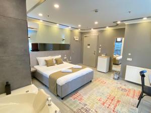 a bedroom with a large bed and a bath tub at Sahrakent Otel Pendik in Istanbul