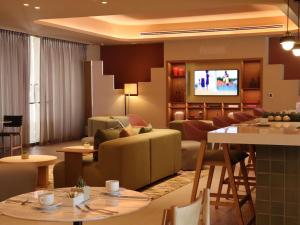 a living room with couches and a flat screen tv at Novotel Mexico City Santa Fe in Mexico City