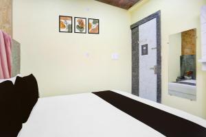a bedroom with a white bed and a bathroom at Hotel O A A Royal in Kānpur +21 photos