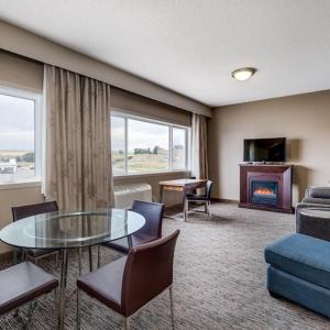 a living room with a table and a couch at Heritage Inn Hotel & Convention Centre - Pincher Creek in Pincher Creek