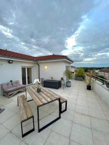 a patio with a wooden table on a roof at Superbe appart design - Rooftop privé proche Paris in Neuilly-sur-Marne