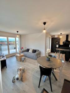 a living room with a table and a couch at Superbe appart design - Rooftop privé proche Paris in Neuilly-sur-Marne