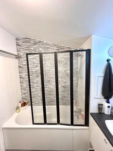 a bathroom with a shower and a tub with a window at Superbe appart design - Rooftop privé proche Paris in Neuilly-sur-Marne +18 photos