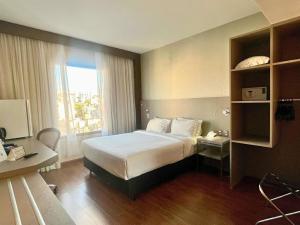 a hotel room with a bed and a desk at Mercure Belo Horizonte Lourdes in Belo Horizonte