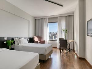 a hotel room with two beds and a window at Mercure Belo Horizonte Lourdes in Belo Horizonte +175 photos