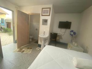 a bedroom with a bed and a toilet and a sink at Che-Joy Budget Lodge in Kitwe