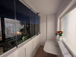 a room with a large window with a table and a bench at Apartament kilometrul 0 Bacau in Bacău