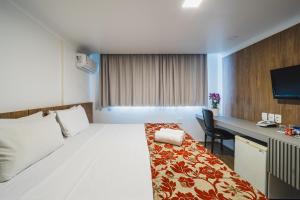 a hotel room with a bed and a desk at Hotel Dan Inn Curitiba Centro By Nacional Inn in Curitiba +77 photos