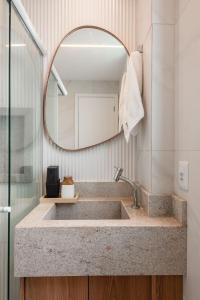 ein Badezimmer mit Waschbecken und Spiegel in der Unterkunft Apto Praia Barra Grande, Camurim Residence in Maragogi