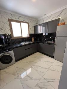 una cocina con refrigerador y lavadora y secadora en Nador Centre, en Nador 11 fotos más