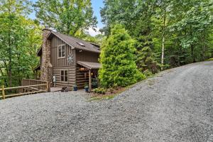 a house on a hill with a gravel driveway at Among The Trees in Vilas