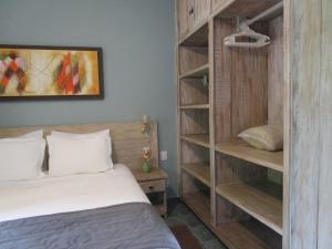 Un dormitorio con una cama y una estantería. en Ilha flat hotel suíte Swaenen, en Ilhabela