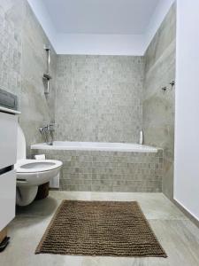 a bathroom with a tub and a toilet and a sink at Richy North in Voluntari +11 photos