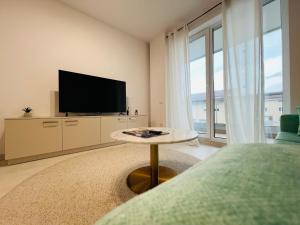a bedroom with a tv and a table and a bed at Richy North in Voluntari