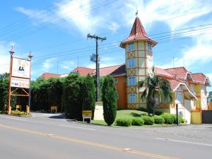 a building with a tower on the side of a street at Exos Castelinho Motel in Concordia