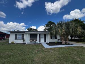 una casa blanca con una palmera en el patio en Renovated Ocala Home Perfect for Families, en Ocala