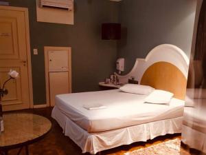 a bedroom with a large bed with an arched headboard at Exos Castelinho Motel in Concordia