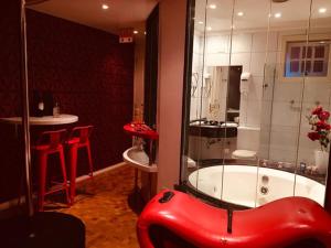 a bathroom with a red tub and a red stool at Exos Castelinho Motel in Concordia +8 photos