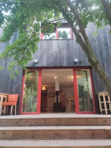 a house with red trim and a tree at Romantický domek Slapy in Brunšov
