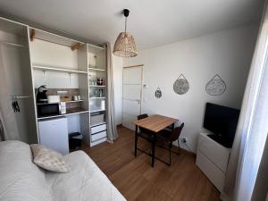 a bedroom with a bed and a table and a kitchen at Chambres modernes avec salle de bain privative in Saint-Pierre-du-Mont