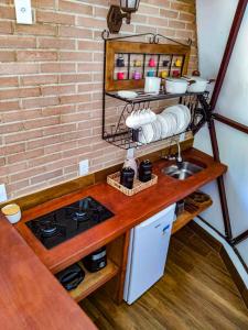 a kitchen with a counter with a stove and a sink at Domo na praia - Arraial D'Ajuda in Arraial d'Ajuda