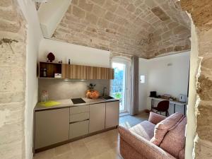 a kitchen with a counter and a living room at Blu Marina Apartment in Giovinazzo