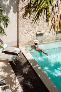 a man in a hat in a swimming pool at The Diplomat Boutique Hotel in Mérida