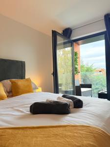 a bedroom with a bed with a large window at Brand-New Luxury Apartment Terrace - Opposite Piccadilly Line - 1-8 Guests in Uxbridge