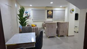 a living room with three chairs and a table at Rennyshouse 3 Bedroom Apartments in Alimosho