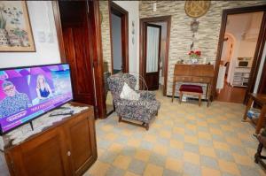 Una sala de estar con un televisor de pantalla plana y una silla. en Casa a dos cuadras de la playa ideal para vacacionar, en Piriápolis