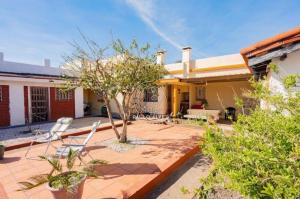 un patio con sillas y un árbol frente a una casa en Casa a dos cuadras de la playa ideal para vacacionar, en Piriápolis