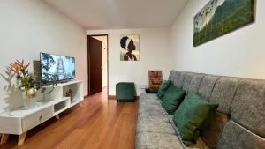 a living room with a couch and a flat screen tv at Dúplex familiar cerca al Cable y Milán con patio in Manizales