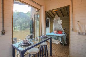 a room with a table and a bed and a window at Casa Flutuante do Lago Cachoeira, Caiaque, Stand UP e Piscina Quinta do Vale in Itatiba