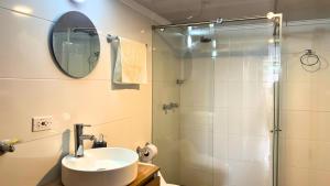 a bathroom with a sink and a shower with a mirror at Dúplex familiar cerca al Cable y Milán con patio in Manizales +12 photos