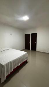 a bedroom with a bed and two closets at Quarto Porto in Porto Seguro