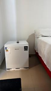 a room with a bed and a white cpu at Quarto Porto in Porto Seguro